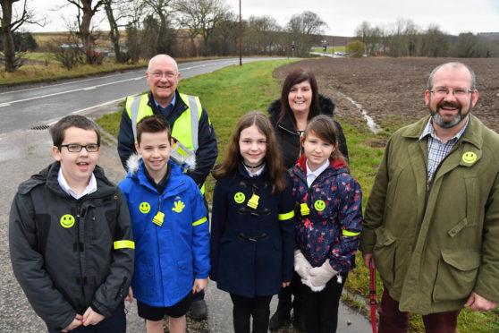 BANFF AND DISTRICT COMMUNITY SAFETY GROUP CHAIRMAN MICHAEL MENARD (L) AND VICE CHAIRMAN MARK FINDLATER WITH KING EDWARD  PRIMARY P7 PUPILS AND HEAD TEACHER AUDREY CLARK DISPLAYING THE RELECTIVE ARMBANDS AND BADGES.