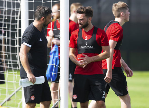 Aberdeen manager Derek McInnes speaks to Graeme Shinnie at training in Dubai.