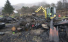Local businesses provided heavy equipment to help clear away the remains of fire damaged buildings.