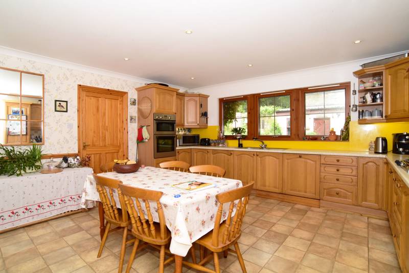 Kitchen: Has a range of wall and floor storage units, space for table and chairs and a door leading through to a utility room