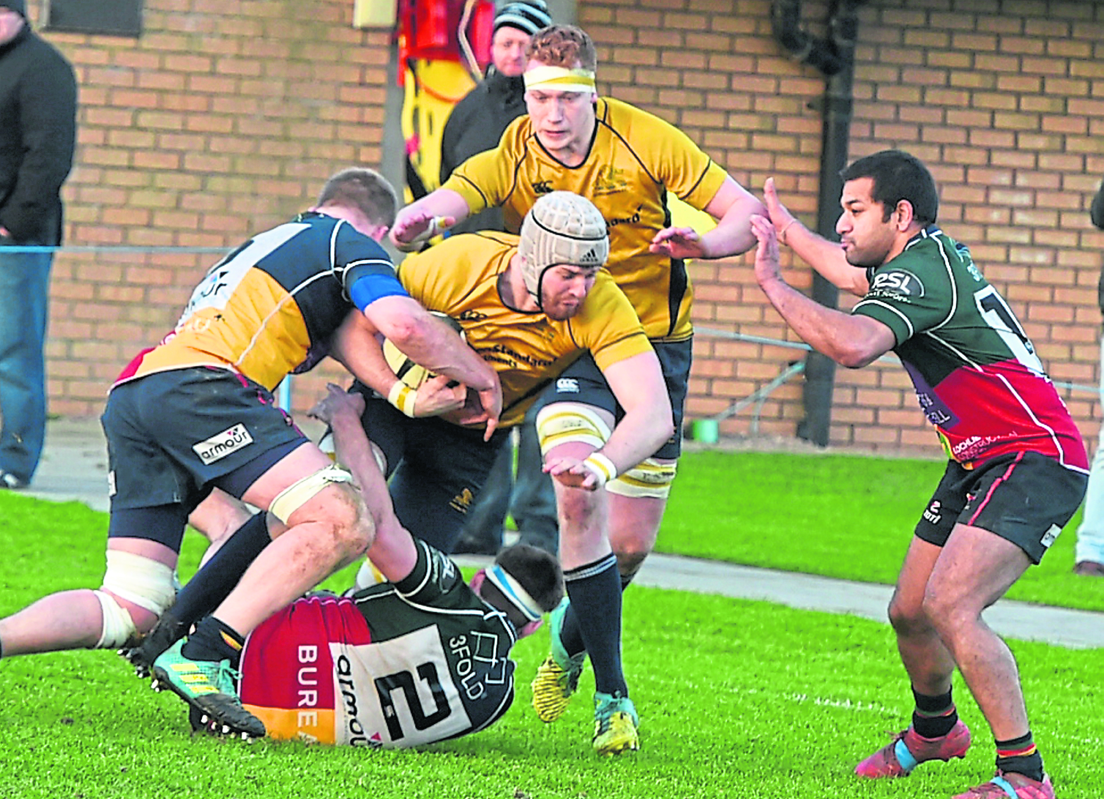 Gordonians’ Chris McIlroy charges forward despite the close attention of a Hillhead Jordanhill player.