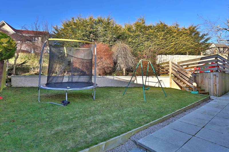 Rear Garden: Incorporates a raised decking area with built-in storage and lawn area