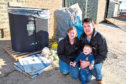 Graham and Ashleigh Thompson, and son Charlie, with the recycling bin they are marketing and some of the items which are collected and baled.