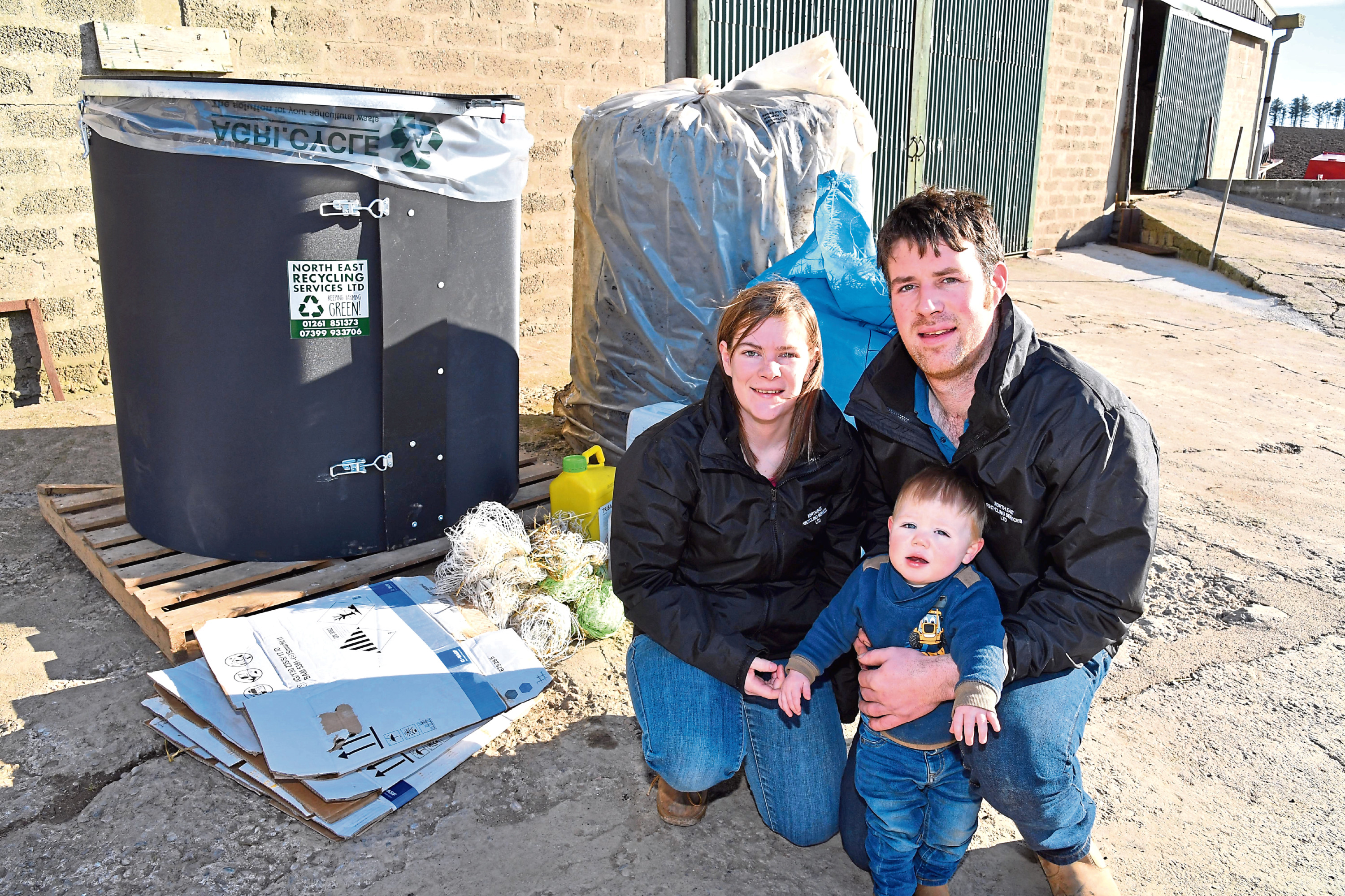 Graham and Ashleigh Thompson, and son Charlie, with the recycling bin they are marketing and some of the items which are collected and baled.