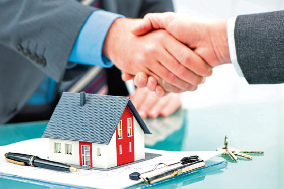 Estate agent shaking hands with customer after contract signature