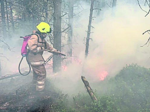 A firefighter battling the flames in Aviemore.