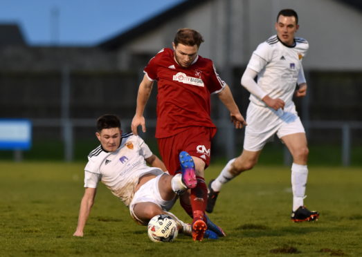 Dane Ballard (red) in action for Deveronvale against Rothes in the Highland League

The Press & Journal Scottish Highland League.
Deveronvale (red) v Rothes (white) at Princess Royal Park, Banff.
Picture of Stephen Rennie (white) sliding in on Dane Ballard (red).