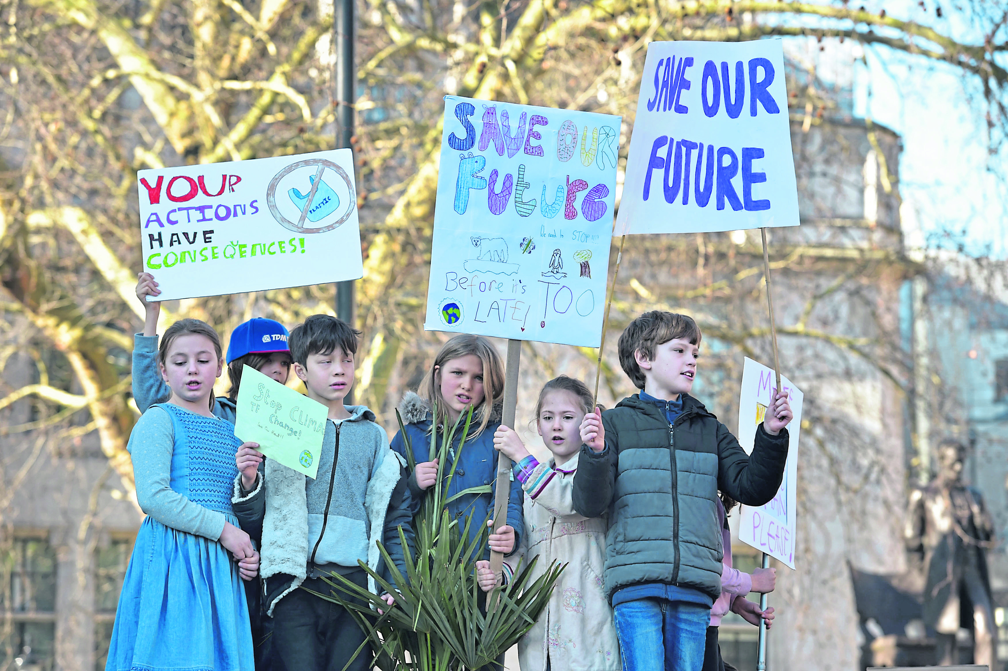 Children with placards during a climate change protest on Parliament Square in London.