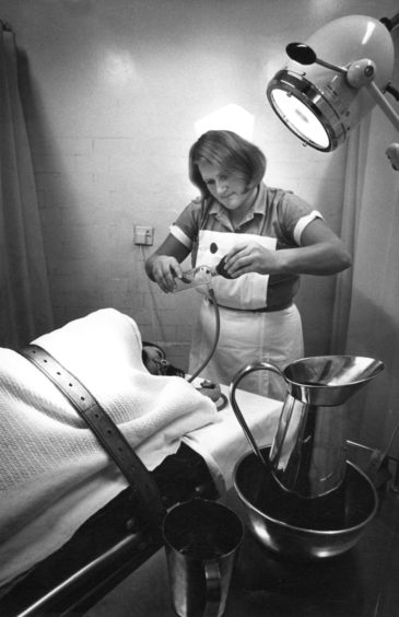 Staff Nurse Tilly Gibbs gives emergency treatment to a patient just admitted to the casualty department in 1976.