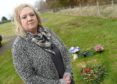 Lynda Fraser at the grave of her husband Stuart in Auldearn Cemetry, where a precious heart shaped wreath was removed by staff while tidying the graveyard of Christmas wreaths.