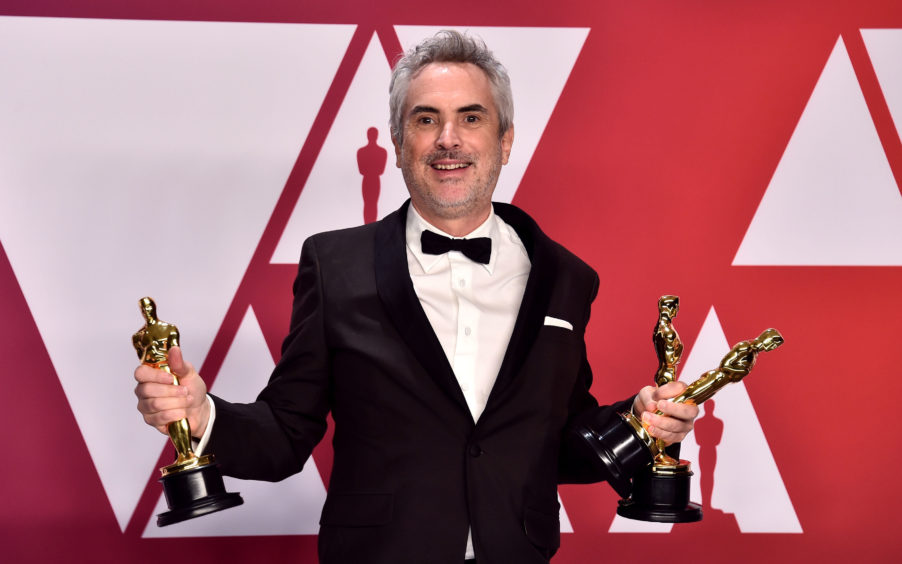 Alfonso Cuaron with his Best Director, Best Foreign Film and Best Cinematography awards.