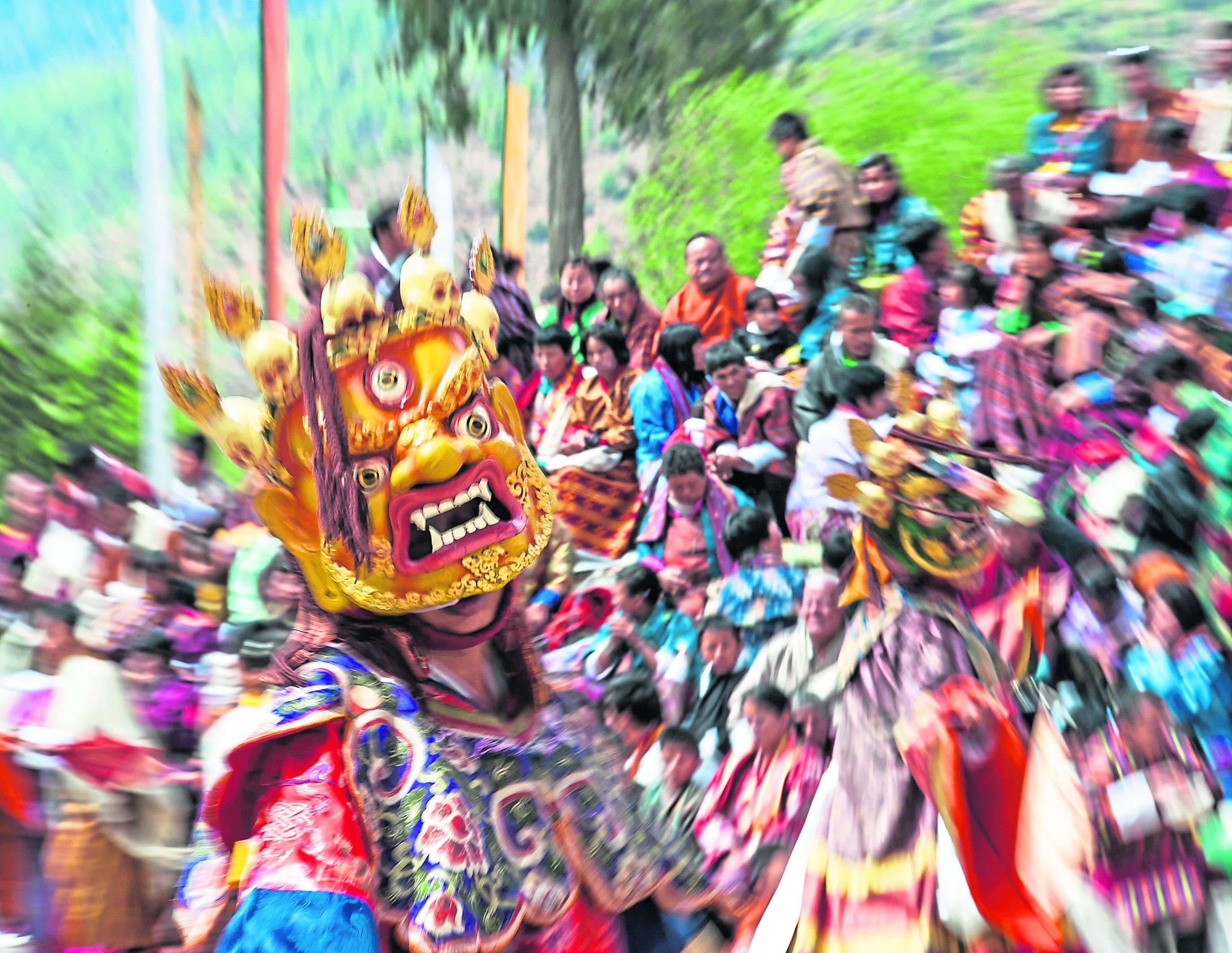 A masked dancer at a festival in Bhutan, where 
its people are stereotyped as being poor but content with their lot in life.