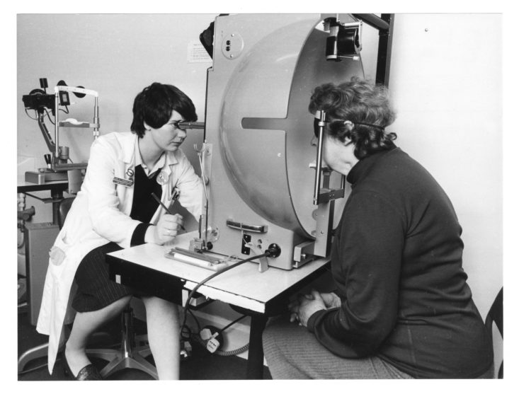Mrs Margaret Hutcheon has her side vision tested by orthoptist Eva Robertson using a Goldmann Perimeter Visual Field testing machine.