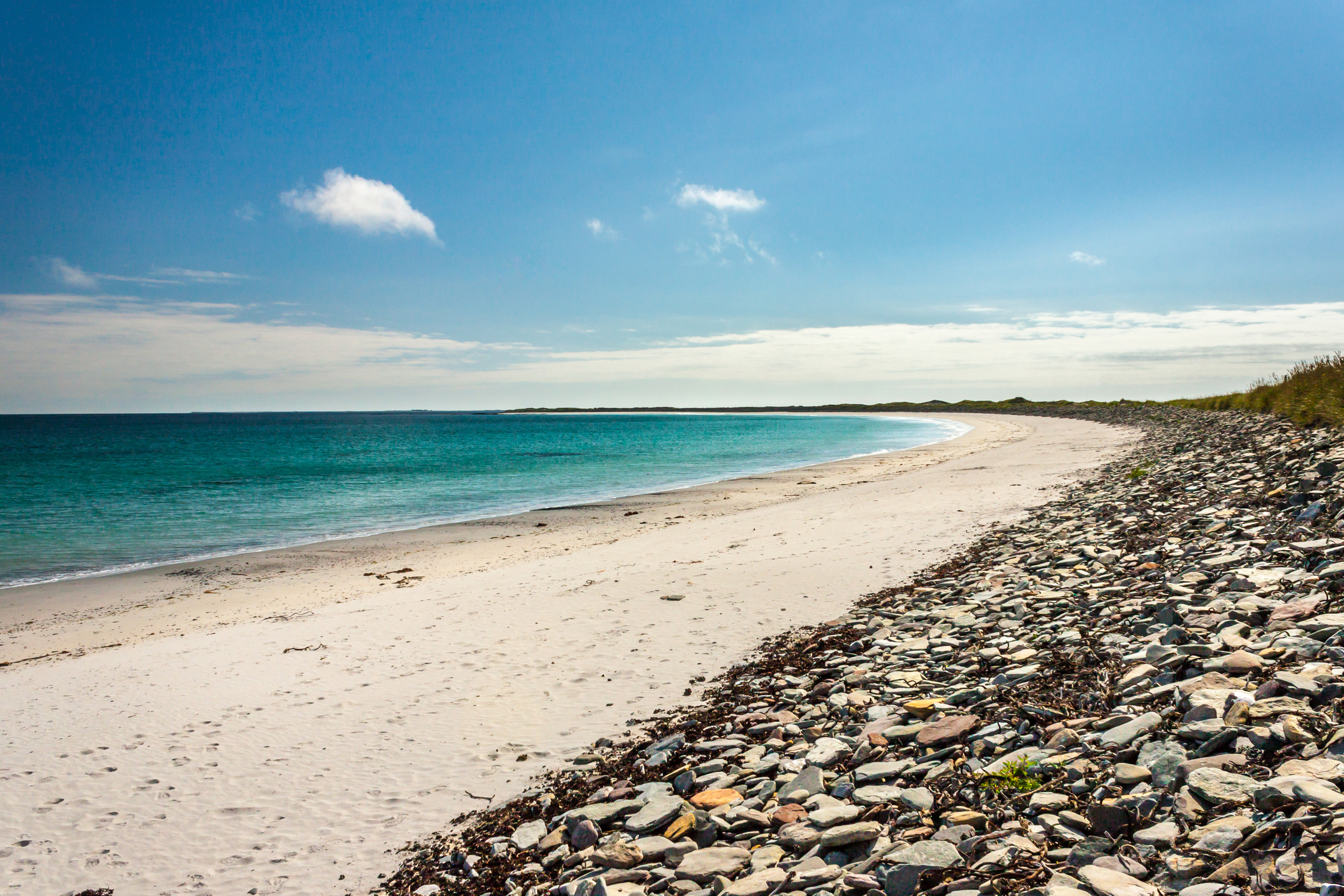 View of remote, white sandy beach at Sanday in Orkney.