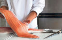 Chef's hand holding fresh piece of salmon

istock