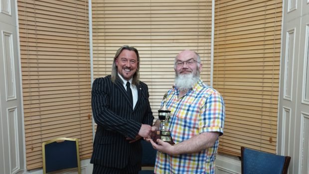 Norn Bichan (right) accepts the Ron Gordon Trophy for Card Magic from Aberdeen Magical Society president Garry Seagraves.