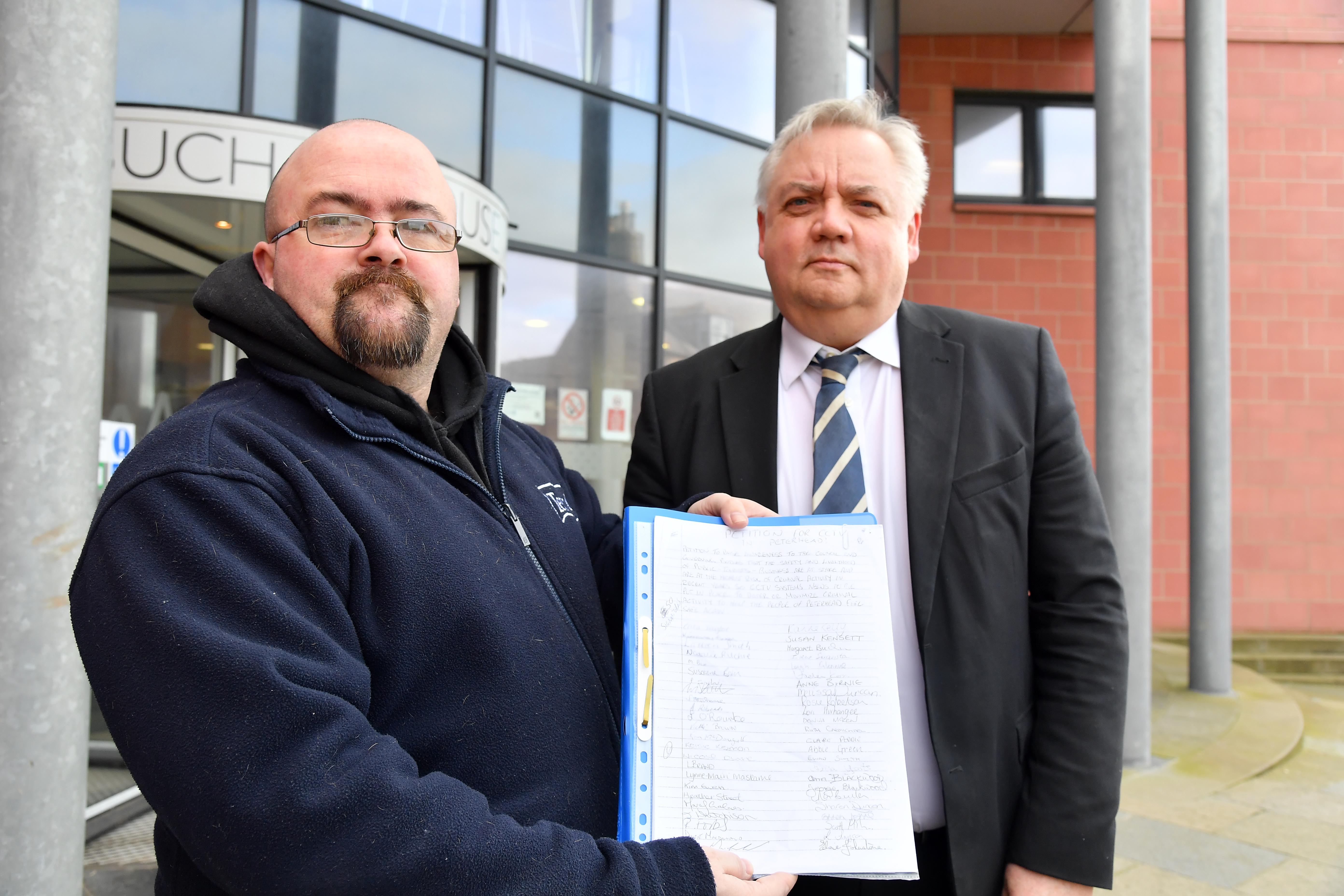 Gilbert Burnett presents the CCTV petition to Chris White from Aberdeenshire Council