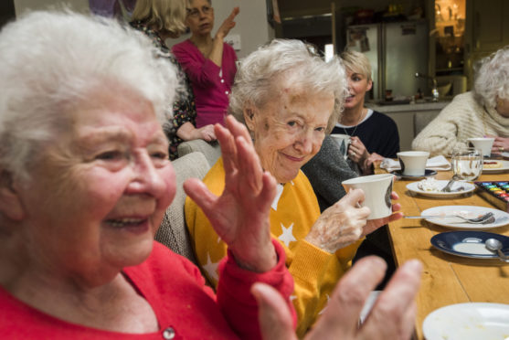 Guests enjoy company at a tea party.