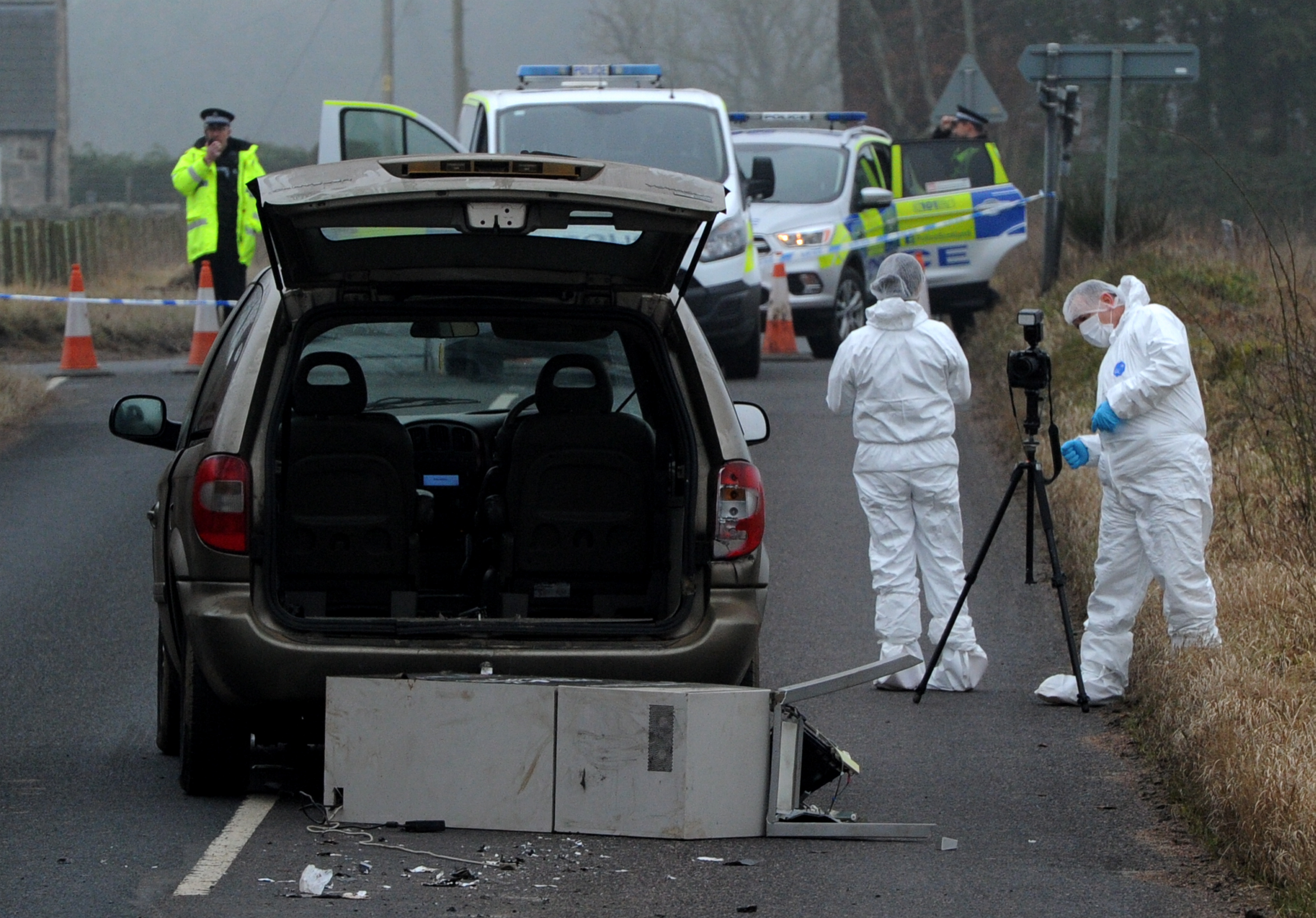 Forensics at the site where the car and ATM were dumped.
