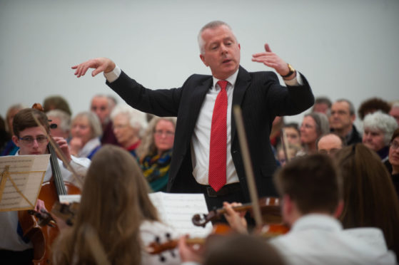 John Mustard conducting the Moray Music Centre orchestra in 2019.