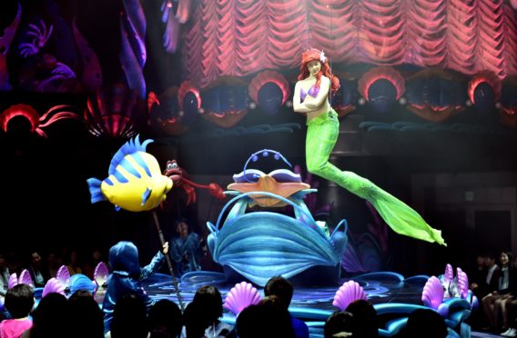 Disney's Little Mermaid character Ariel sings and displays wire-action performance in the air during the press preview of the new attraction "King Triton's Concert" at the Tokyo DisneySea in Urayasu, suburban Tokyo on April 20, 2015. The new musical show will open for public from April 24. Disney theme park Tokyo Disneyland and Tokyo DisneySea marked record high visitors of 31.38 million in the fiscal 2014 year ended March.   AFP PHOTO / Yoshikazu TSUNO        (Photo credit should read YOSHIKAZU TSUNO/AFP/Getty Images)