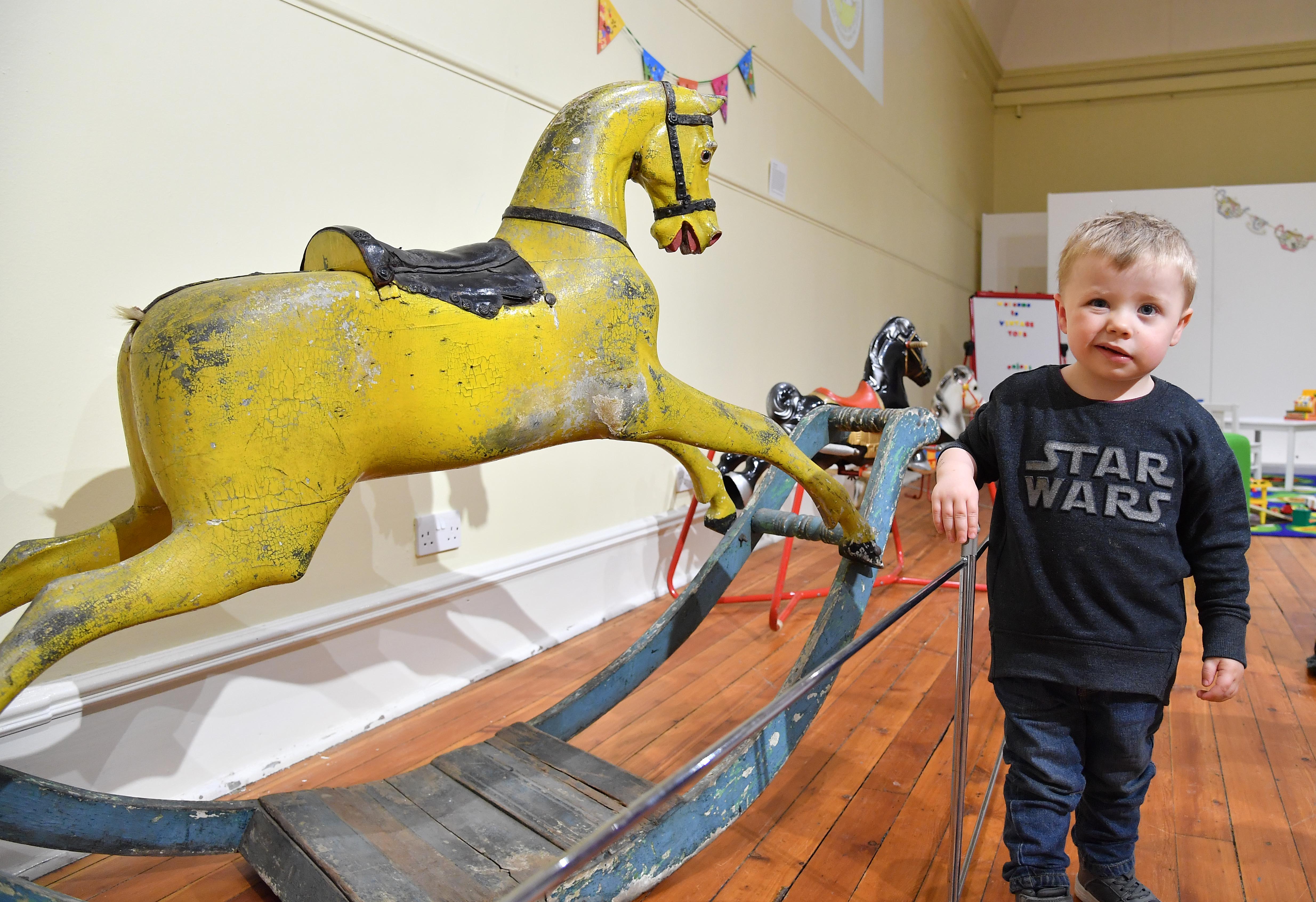 Arbuthnot museum are displaying a collection of vintage toys. Visitor Jack Massie (3) from Aberdeen beside a collection of vintage rocking horses.