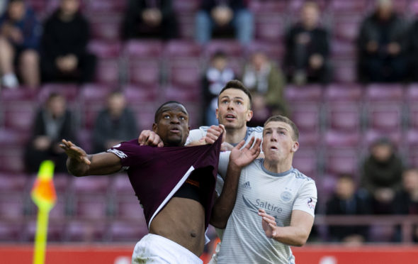 Andy Considine and Lewis Ferguson grapple with Uche Ikpeazu.