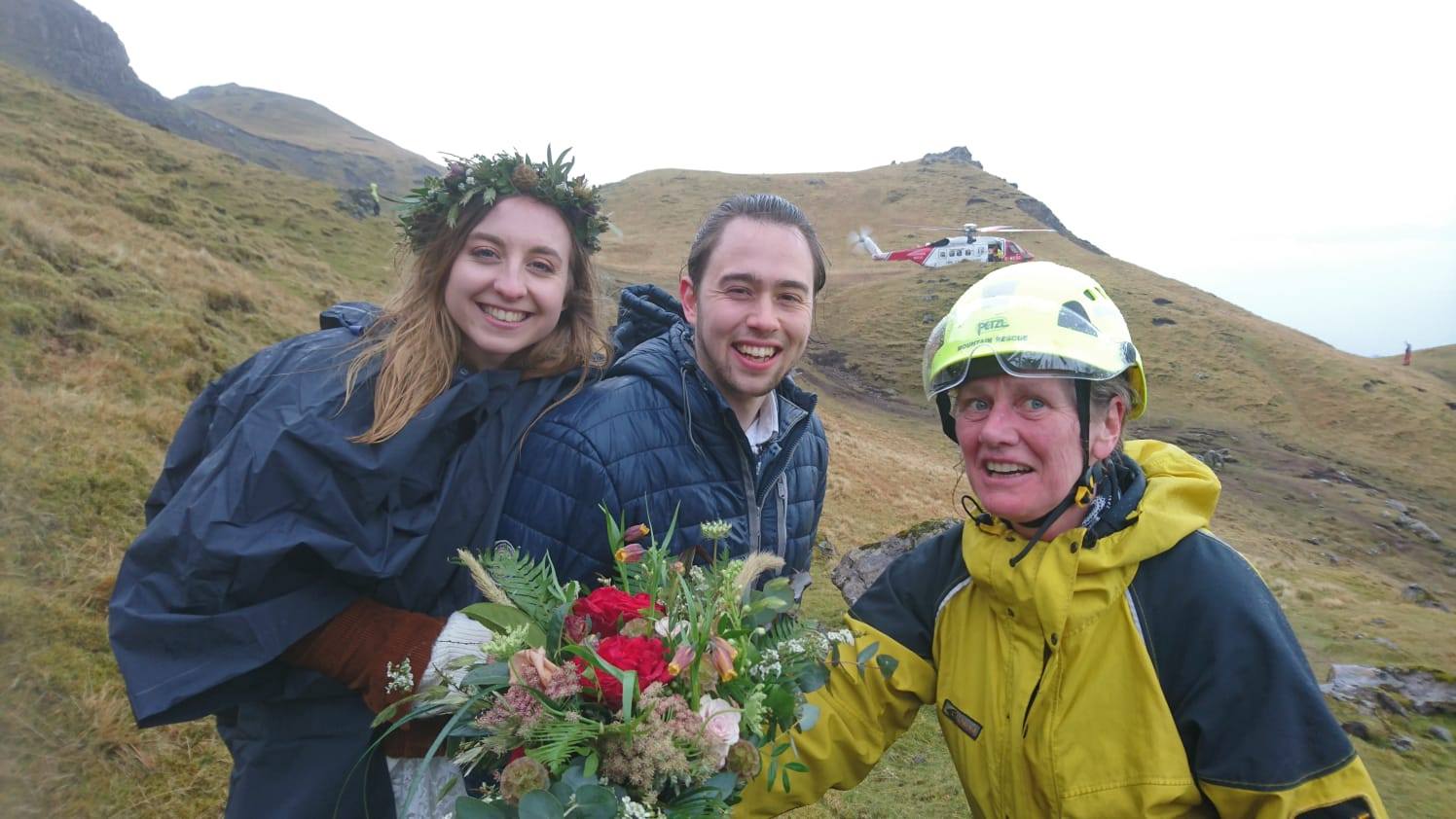 Skye Mountain Rescue Team member Helen Urquhart stops for a moment to have her photo taken with a newly married couple.