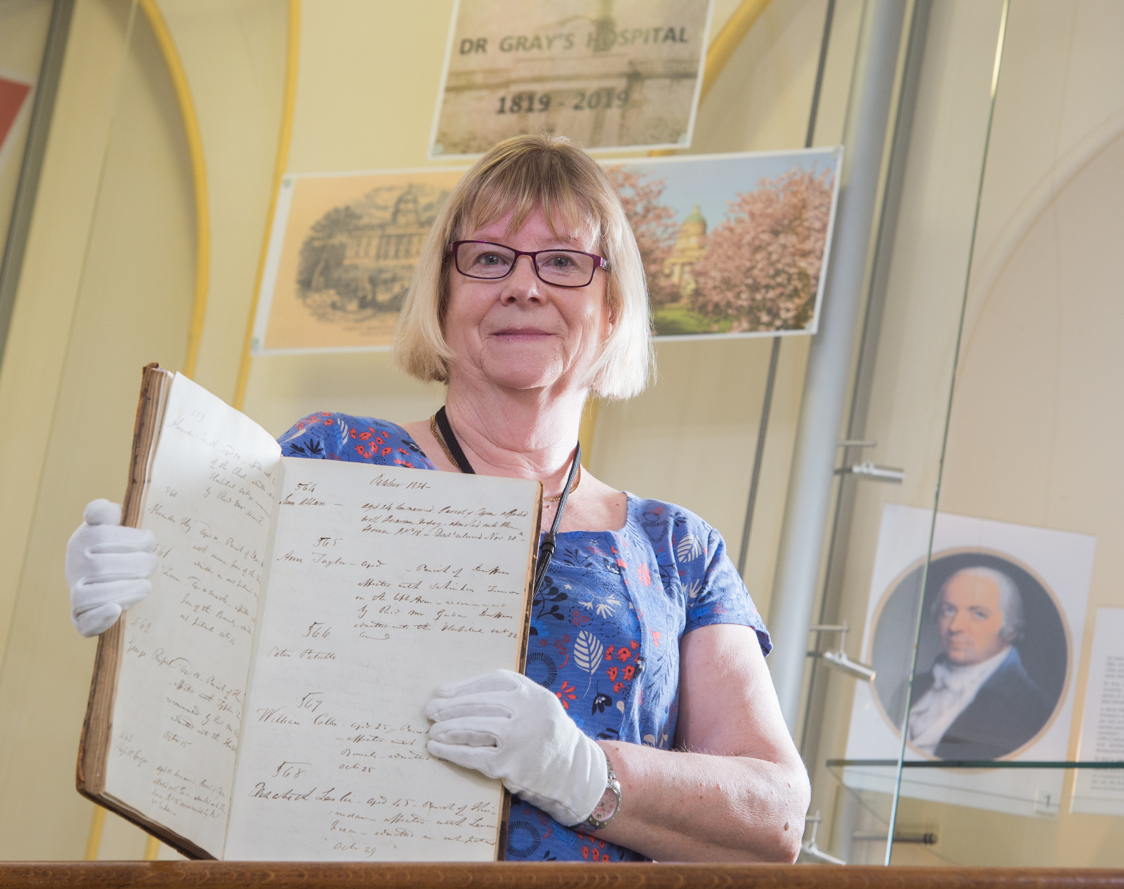 Elgin Museum Janie Mackenzie with the original admissions book for Dr Gray's Hospital from when it opened in 1819.