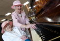 Elsie Walker and Cathie Knox play a rendition of Jesus Loves Me on the piano