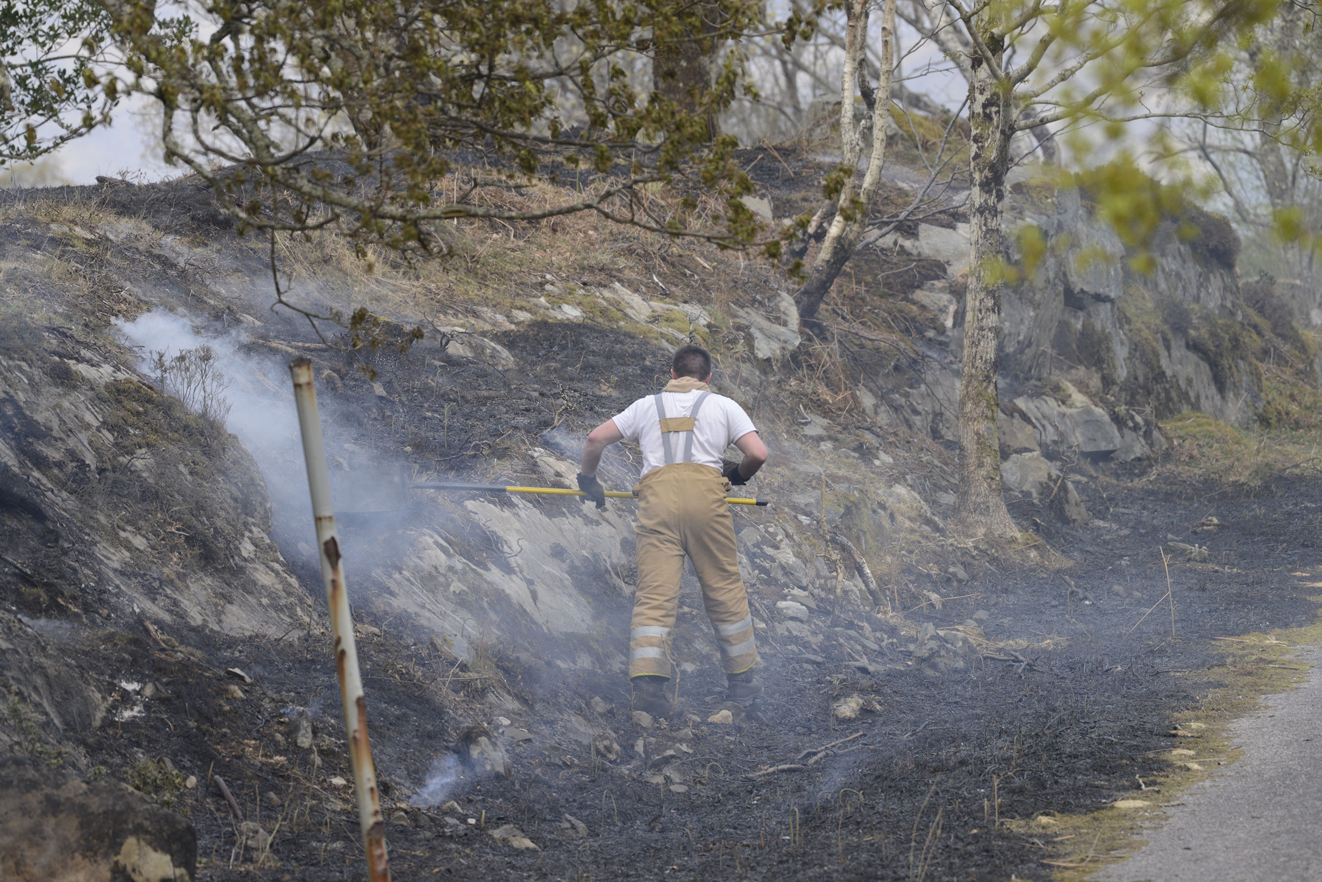 A firefighter works on keeping the flames from breaking out again in the fire ravaged glens between Lochailort and Morar.