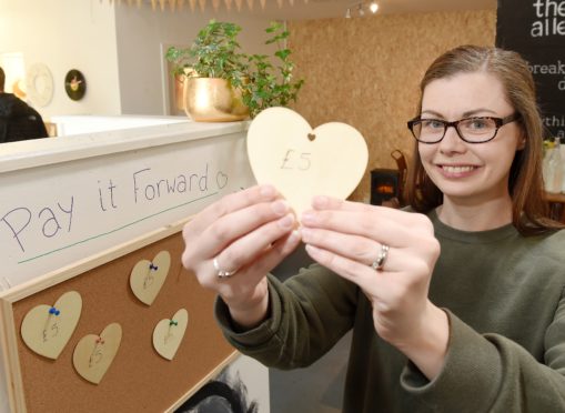 Claire Reed of The Alley Cat in Mealmarket Close in Inverness with their 'Pay it Forward' tokens.