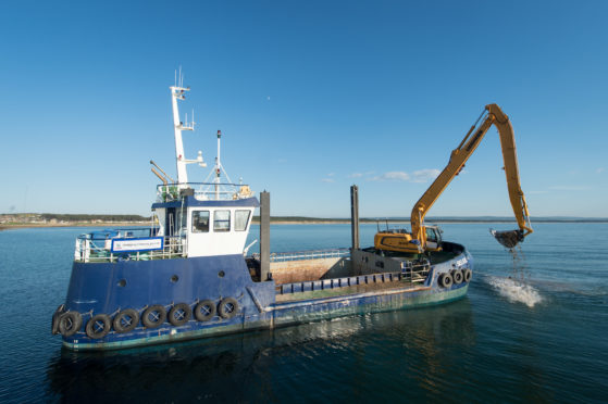 Moray Council's dredger, Selkie, in operation at Burghead.