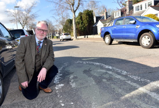 Worn out 20mph sign on Angusfield Avenue with Councillor John Cooke