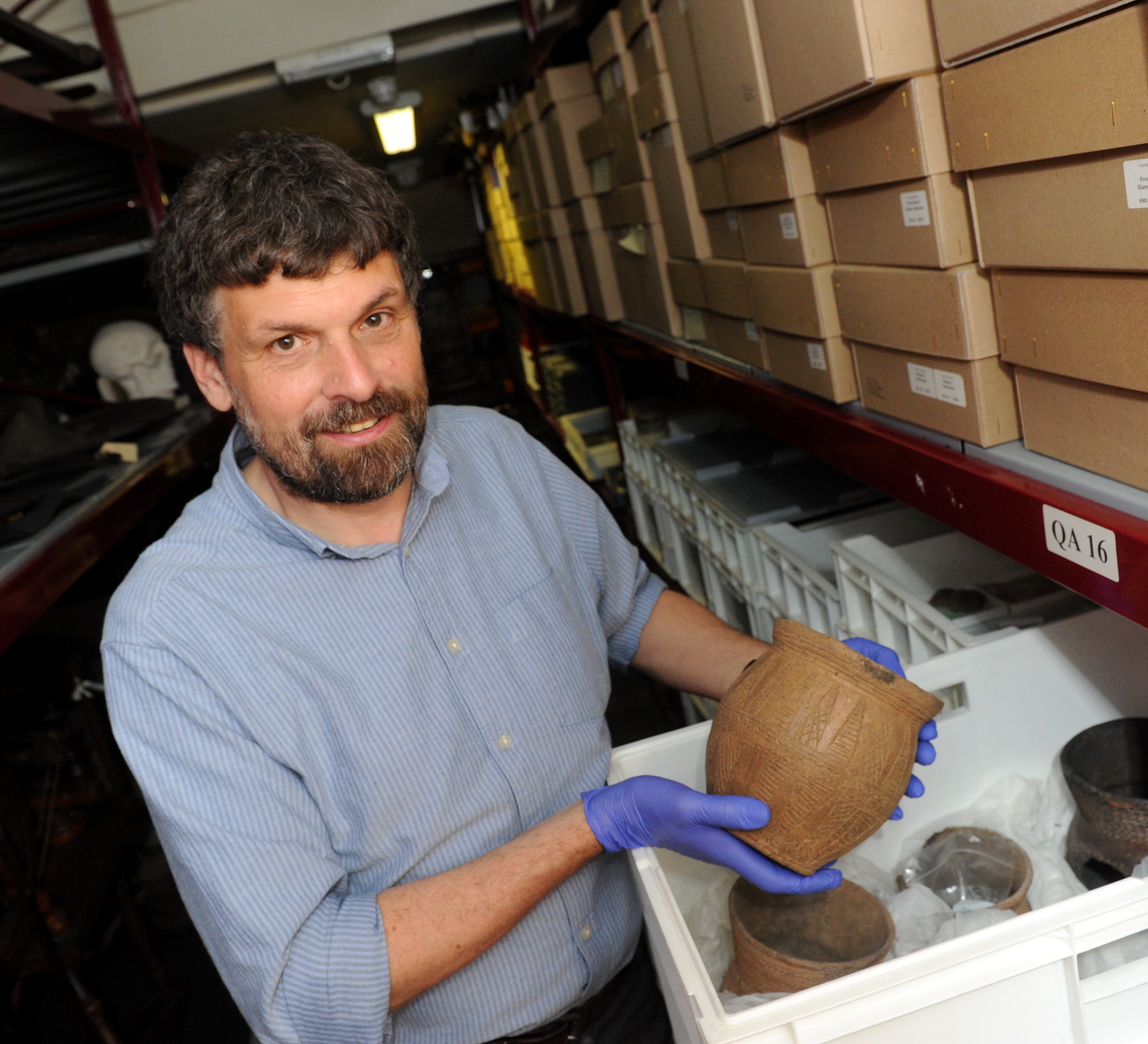Picture from 2016 of University of Aberdeen Head of Museums Neil Curtis with a prehistoric beaker found in Chapelden