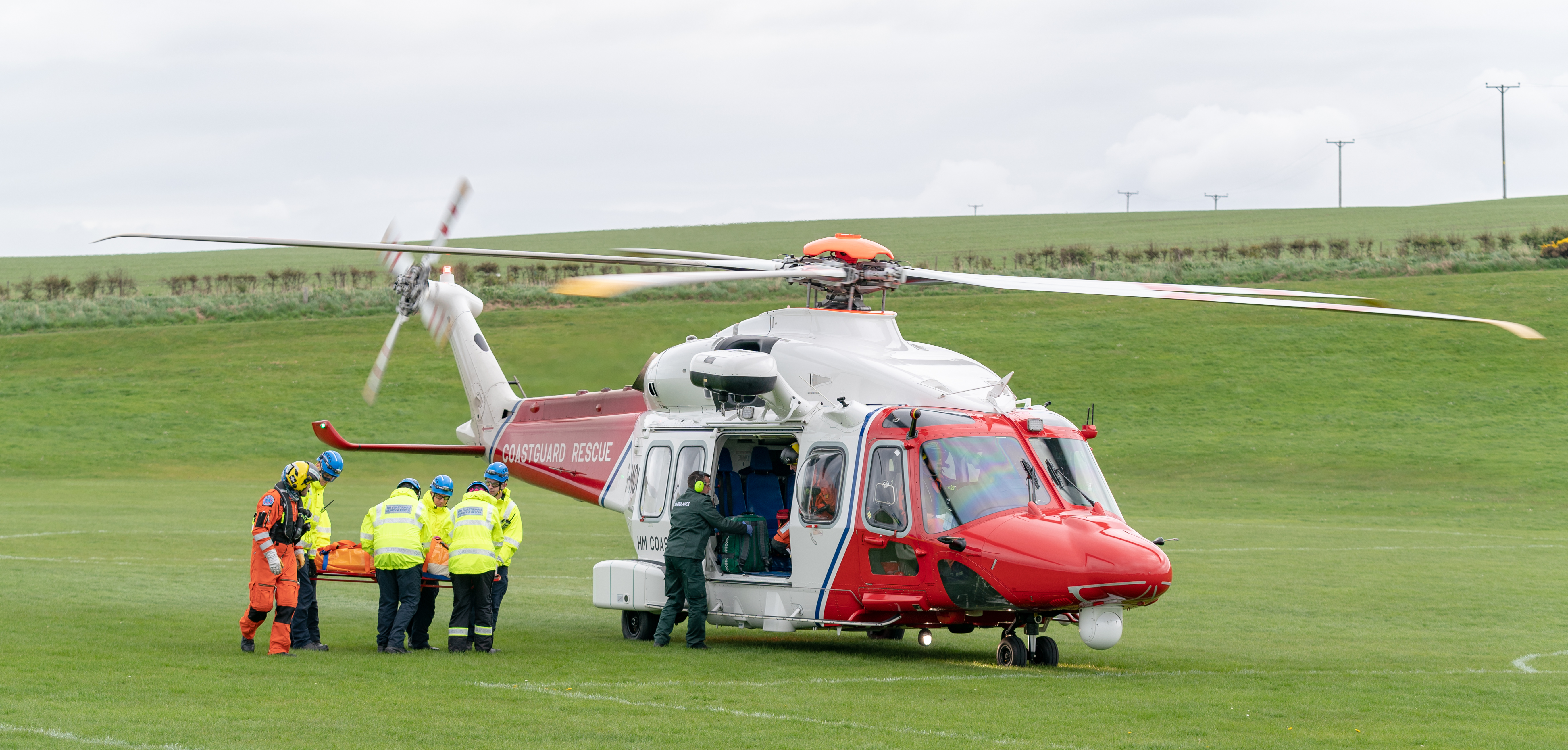 This is from the rescue of a party that fell and injured themselves within the Rotary Club of Buckie, Charity Event, 6 Harbours Walk, Scotland. It is understood that a participant fell and was unable to walk, whereby Coastguard Ground and Helicopter Teams were deployed to manage the casualty. The Casualty would have been placed into the Helicopter in the area of Crannoch Hill, Cullen and taken to Ambulance at Cullen Bay Holiday Park. The party was then taken to Dr Grays Hospital, Elgin. It is not thought that injury is Life Threatening. Photographed by JASPERIMAGE © - PICTURE CONTENT: - The Patients is removed from Rescue 151 from Inverness by Coastguard Teams from Buckie and conveyed on stretcher to aawaitin Ambulance