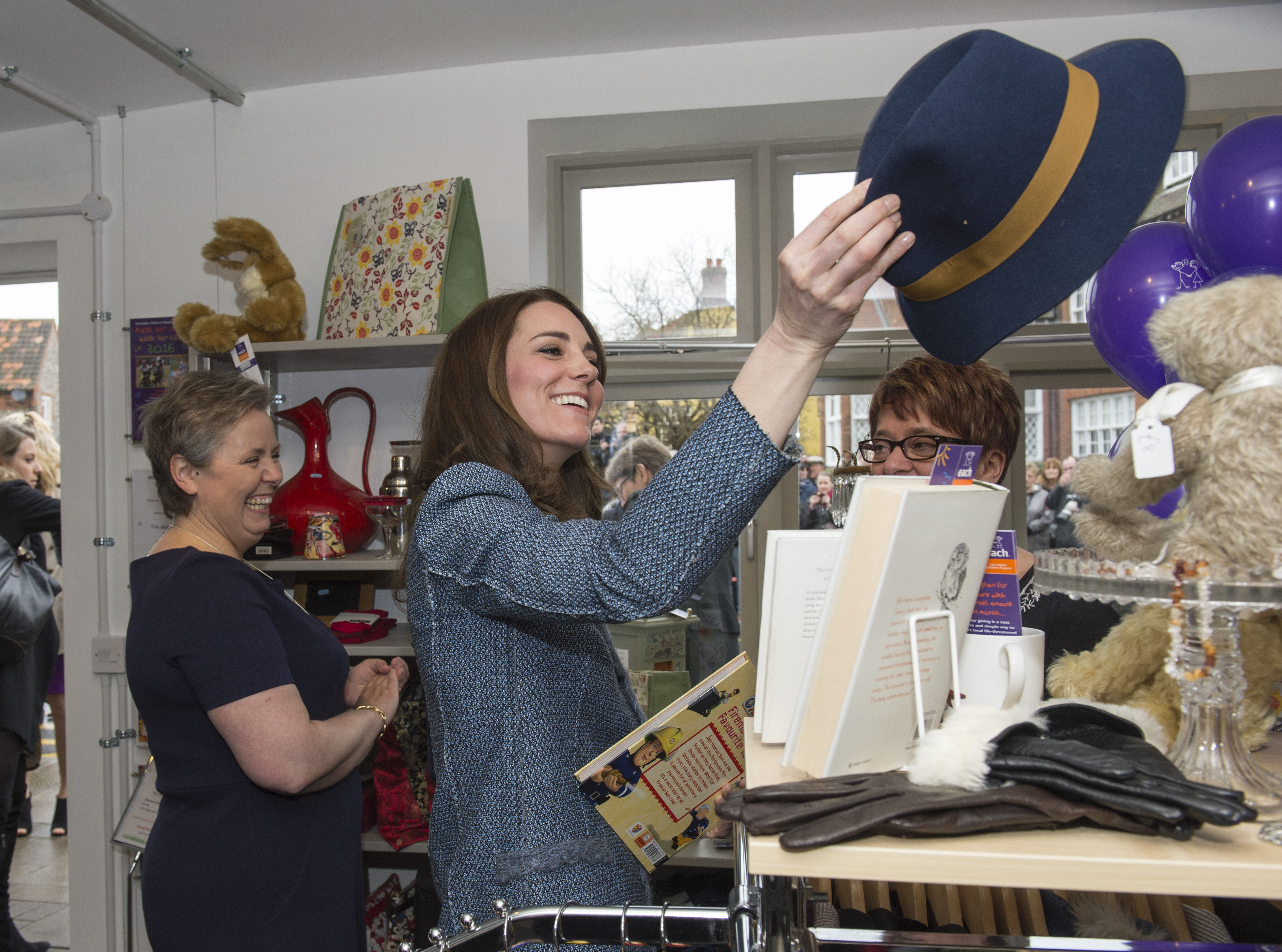 HOLT, UNITED KINGDOM - MARCH 18:  Catherine, Duchess of Cambridge tries on a Boden hat, priced at £15, as she takes a tour of the new EACH charity shop that she officially opened earlier today on March 18, 2016 in Holt, United Kingdom. (Photo by Arthur Edwards - WPA Pool/Getty Images)