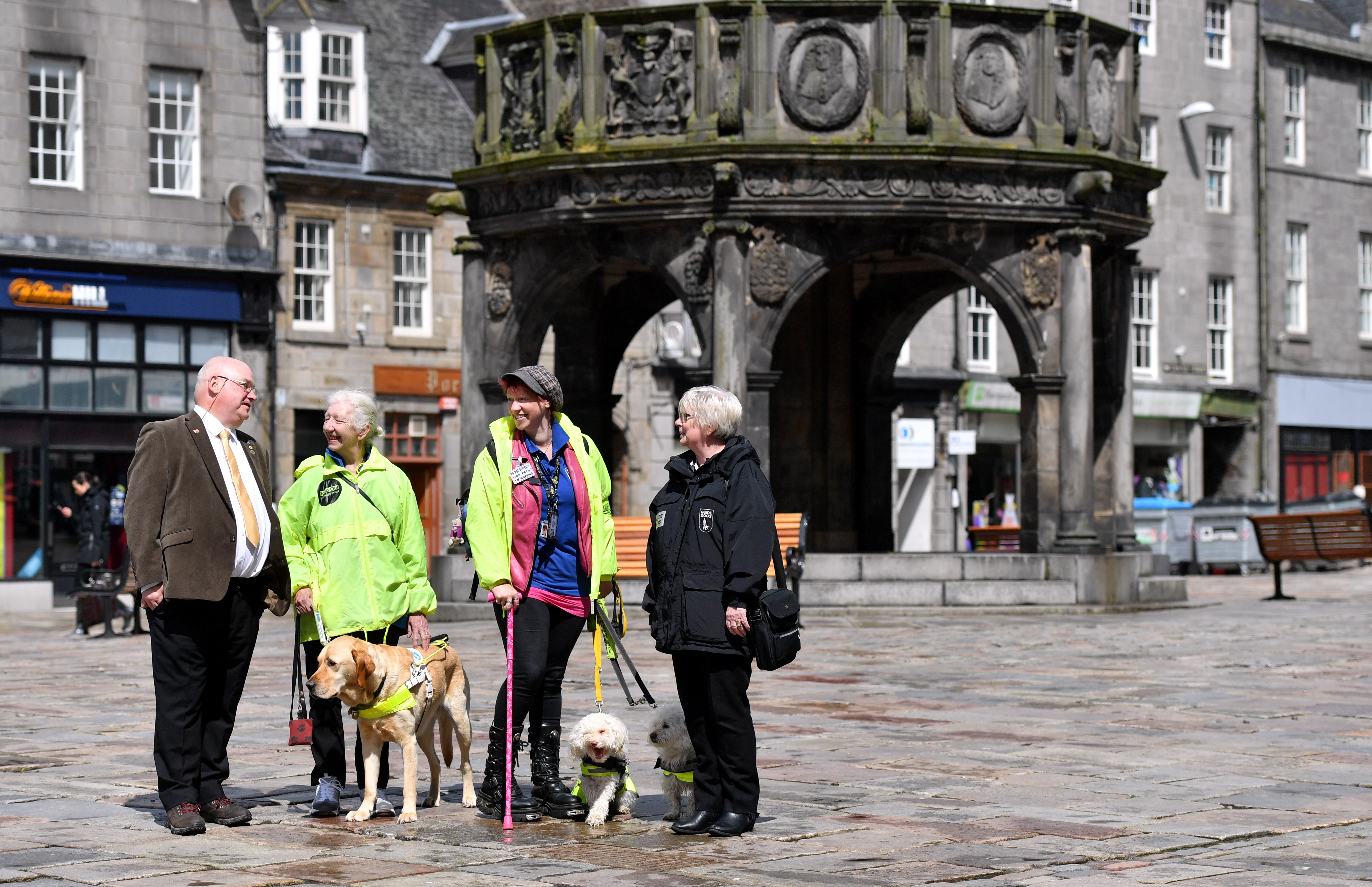 Dell Henrickson, Mary Rasmusen with her guide dog Vince, Ells McHaffie with her assistance dogs Alfie and Blossom, and Pamela Munro of Guide Dogs