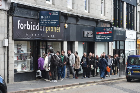 Customers wait for the shop to open.