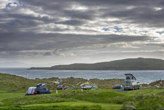 Campervans and tents on campsite along Loch Gairloch, Wester Ross.
