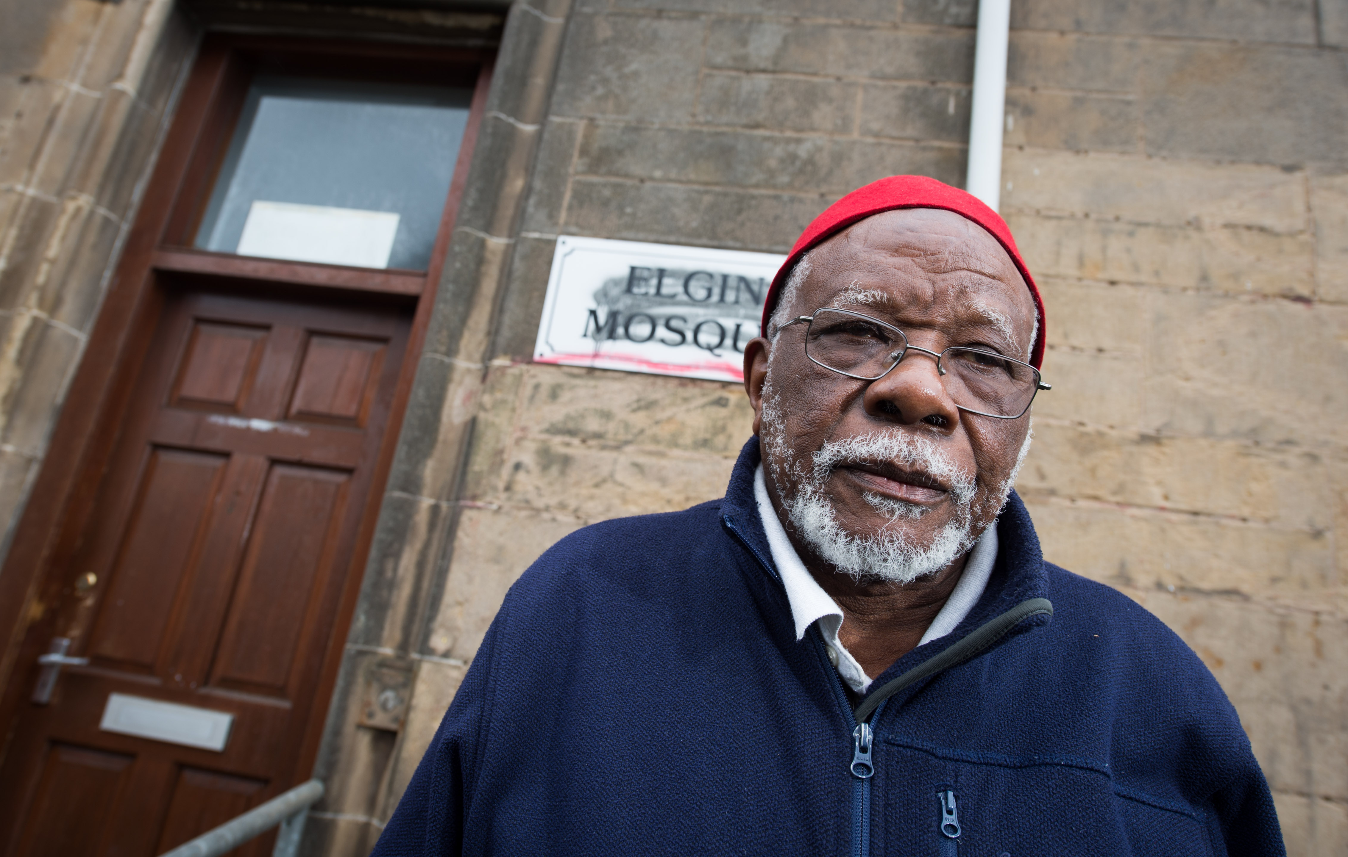 Lansana Bangura, chairman of Elgin Mosque, stands with some of the graffiti.