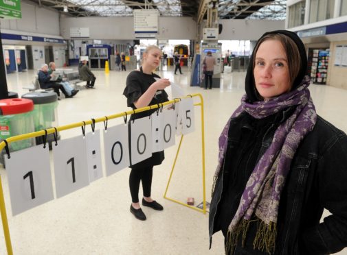 Artist Janine Harrington and member of the public Alexandra Cristache try to keep time with the human powered digital clock on display in Inverness Railway Station yesterday. Picture by Sandy McCook.