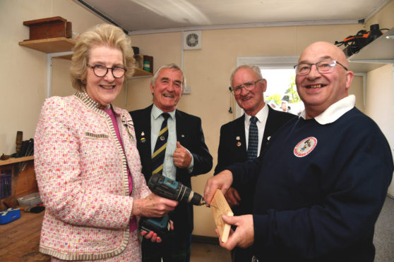 BANFFSHIRE LORD LIEUTENANT CLARE RUSSELL VISITS THE WOODWORKING SECTION AFTER OPENING THE MENS SHED AND PROVED SHE KNOWS THE DRILL TO SECRETARY JIM PATERSON WATCHED BY VICE CHAIRMAN DOD CHRISTIE (L) AND CHAIRMAN KENNY CHRISTIE.