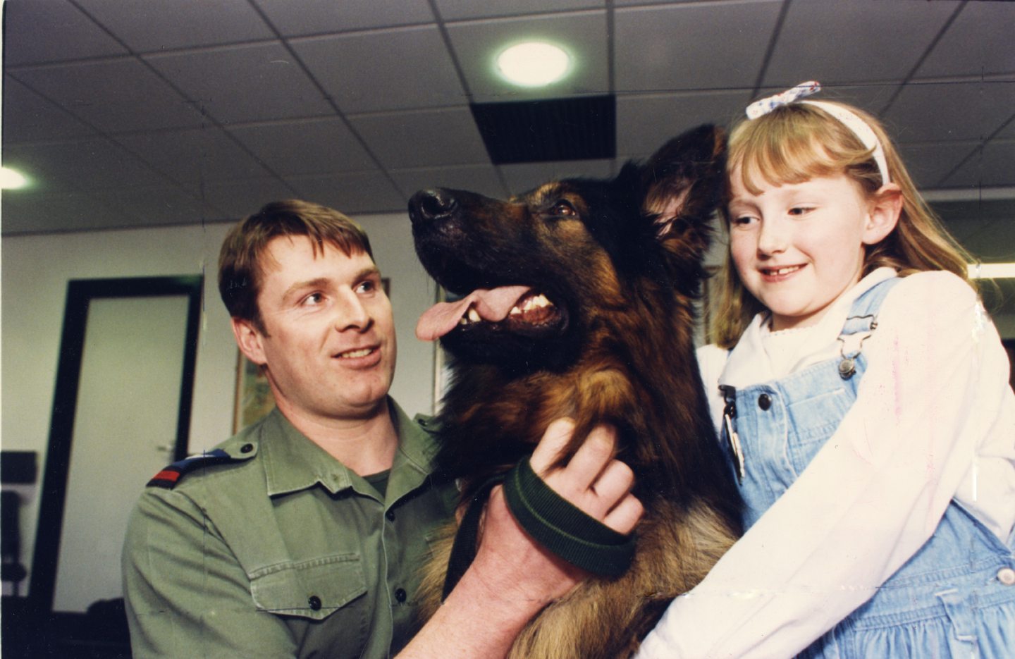 Dr Gray's Hospital patient Fiona Urquhart, 7 cuddles RAF Police dog Banjo, held by Cpl Ian Booth." Picture taken 27 March 1990.