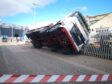 A lorry toppled over during a delivery and pinned a man to a fence.
