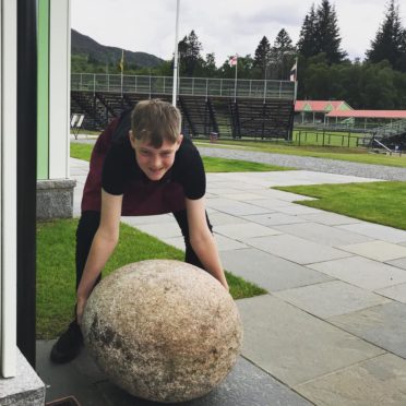 A young employee tries his hand at lifting the Invercauld Stone