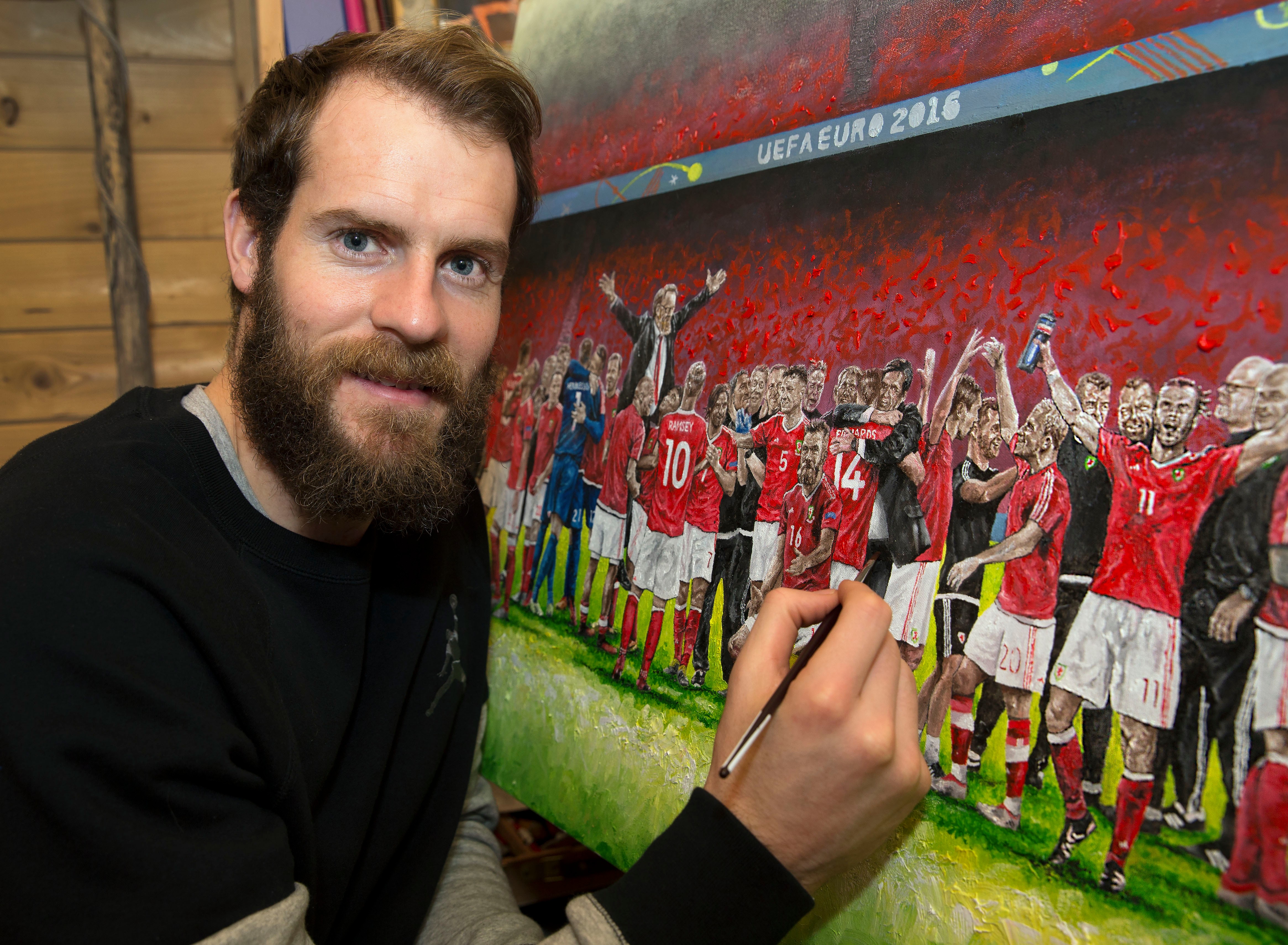 Owain Fon Williams with one of his paintings of the Wales national side.