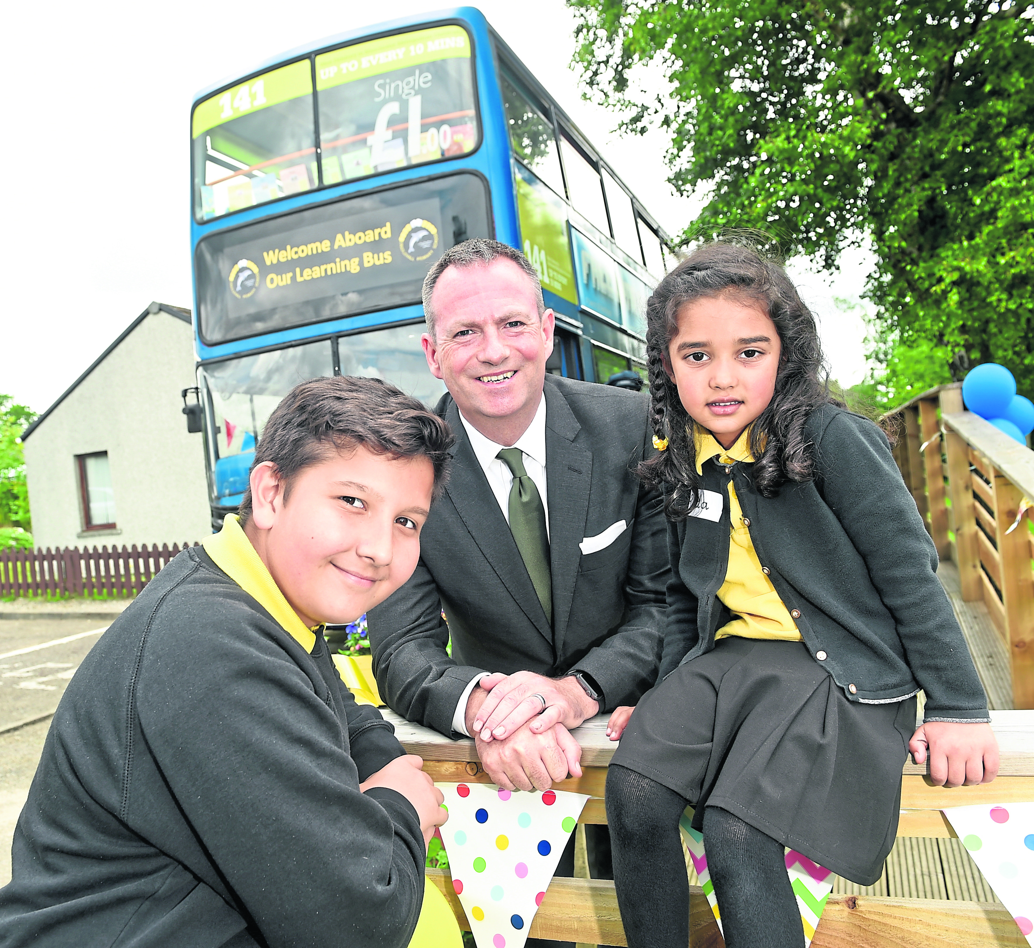 The youngest and the oldest pupils of Cradlehall Primary School, Inverness, Rida Aslam (5) and Ziya Demirel (12) photographed with David Liston, Managing Director of Stagecoach North Scotland and the double decker bus which the company hs donated to the school as a learning facility.
Picture by Sandy McCook