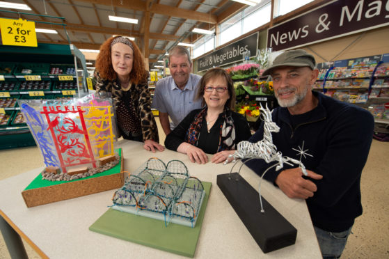 Maggie Clyde with her model Buckie in Steel, Buckie councillors Gordon Cowie and Sonya Warren and Carn Standing with his model called Buckie's Darling.