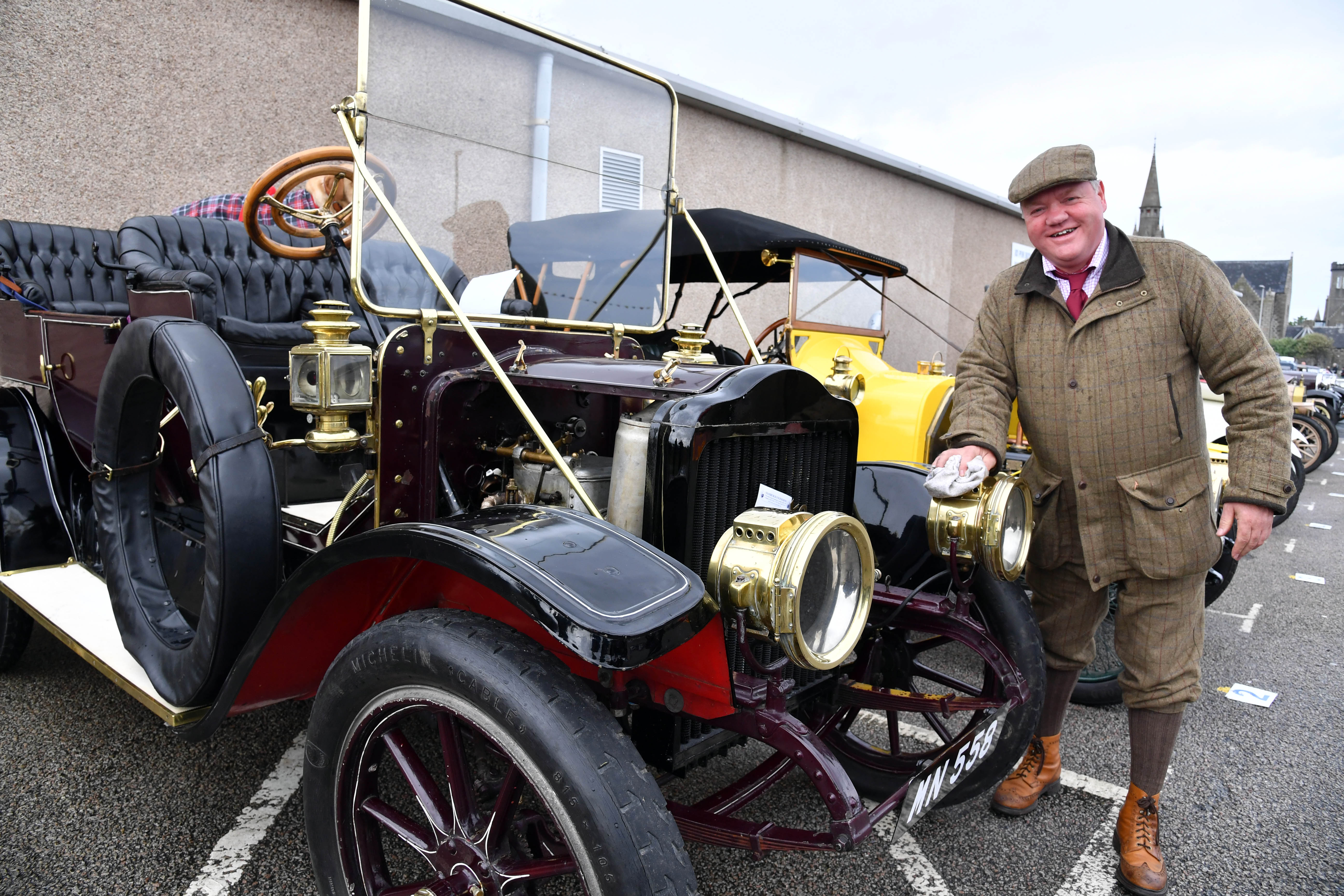 Owner Alfie Cheyne polishes the brass headlamps on his 1910 Whye steam car.